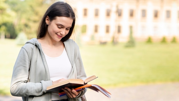 Stylish young student reading book