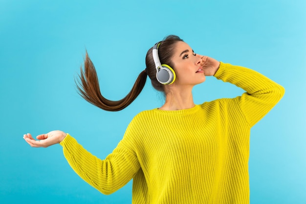 Stylish young woman holding listening to music in headphones