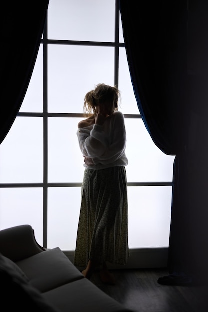 Stylish young woman in modern interior in the contrasting light