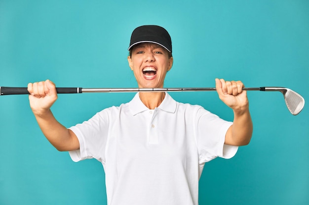 Stylish young woman playing golf in studio