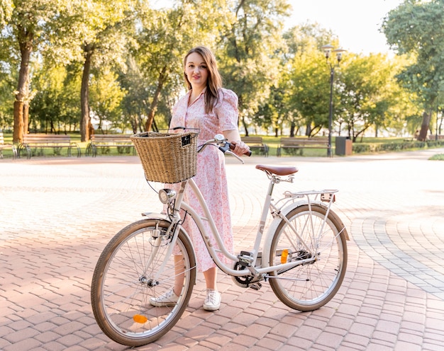 Stylish young woman posing with bike