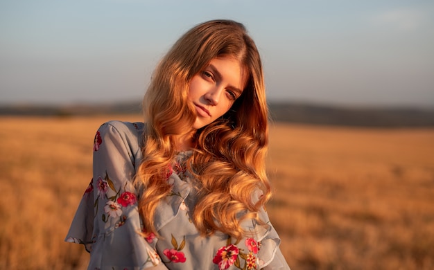 Stylish young woman standing in field