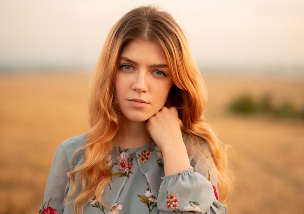 Stylish young woman standing in field