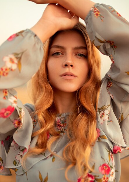 Stylish young woman standing in field