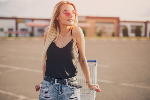 Stylish young woman with shopping trolley