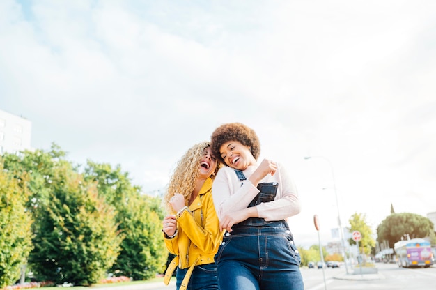 Stylish young women having friendly meeting walking in the street. LGTB concept