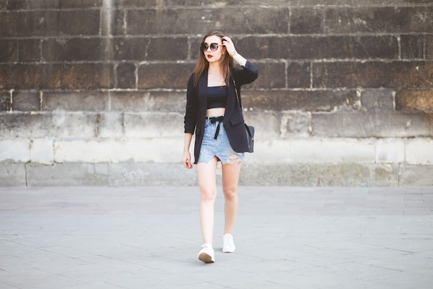 Stylishly dressed young brunette walking around the city