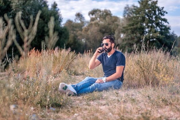 Stylishvape man in the fresh air smoking an electronic smoke device. Handsome man.