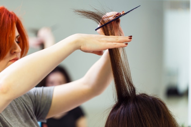 Stylist align the customer's hair with straightener