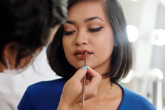 Stylist making makeup to woman