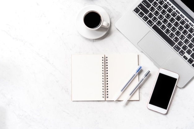 Stylized marble office working desk with smartphone, laptop, glasses and coffee