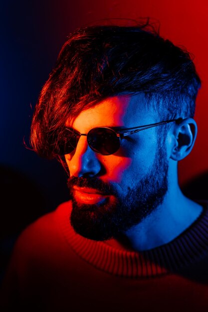 Stylized portrait of a man with a beard and black modern glasses using 2 sources of colored light