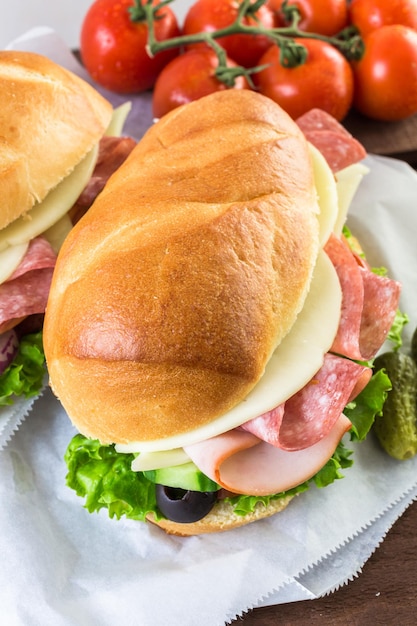 Sub sandwich with fresh vegetables, lunch meat and cheese on hoagie roll.