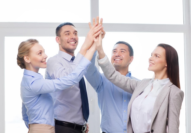 success, business, office and winning concept - happy business team giving high five in office