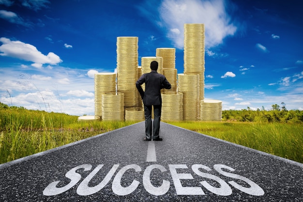 Success concept with businessman standing on long road