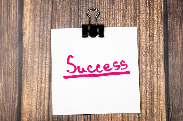 SUCCESS text on a sheet on a wooden table