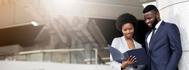 Successful african american business partners checking financial reports outdoors copy space