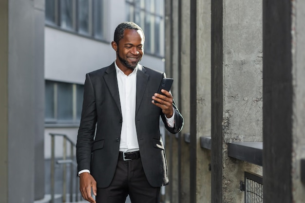 A successful african american businessman in a business suit is standing on the street near a