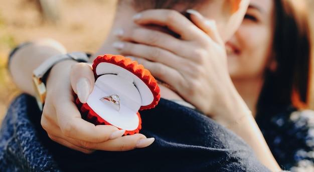 Successful asking for marriage of a caucasian man with red ring box embraced by his future wife