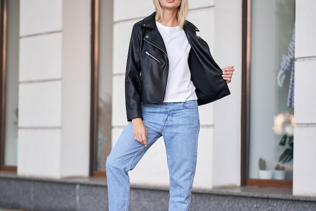 Successful blonde woman wears black jacket with white shirt