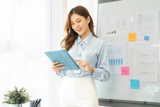 Successful business concept Businesswoman smiling and using tablet to reading financial report