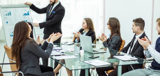 successful business team applauding the Manager Finance on the presentation of the new project in the workplace in the office