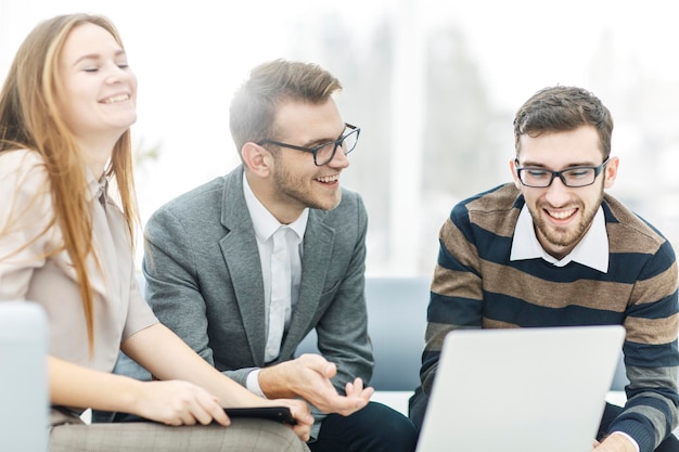 Successful business team with laptop at workplace discuss working questions