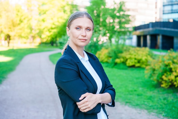 Successful business woman smiling happy with arms crossed arms in city against