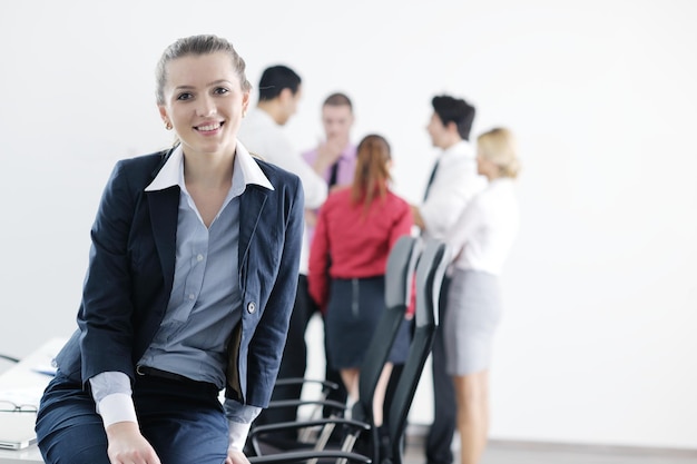 Photo successful business woman standing with her staff in background at modern bright office