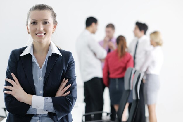 Photo successful business woman standing with her staff in background at modern bright office