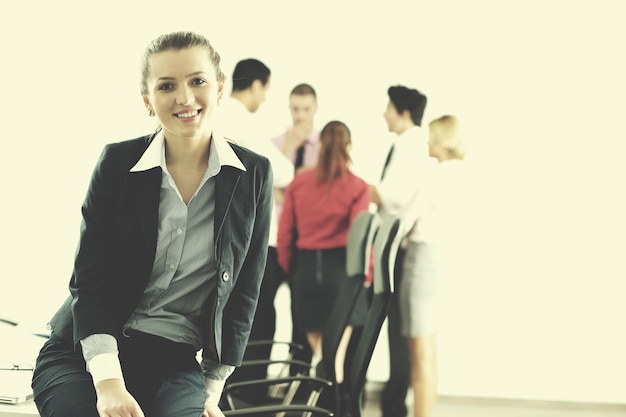 Photo successful business woman standing with her staff in background at modern bright office