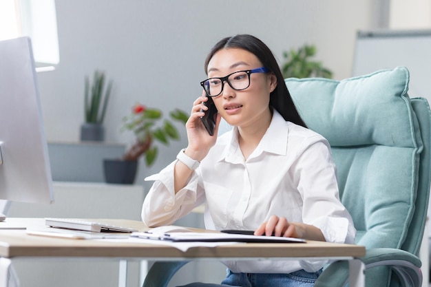 Successful business woman working in modern office asian woman talking on the phone female worker