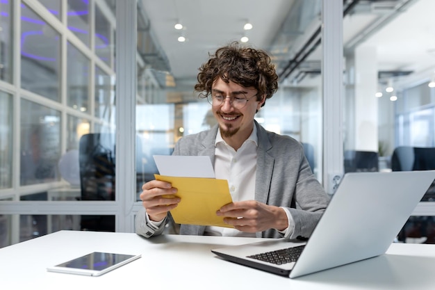 Successful businessman inside office at work man received notification mail with good news hispanic