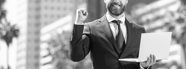 Photo successful businessman in suit standing outdoor with laptop networking