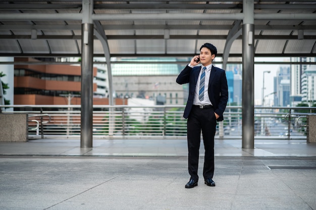 Successful businessman in suit talking a mobile phone in the city