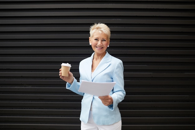 Successful businesswoman with coffee outdoors