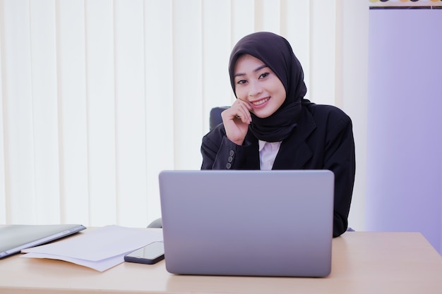 Successful businesswoman working on laptop computer and thinks on new ideas in her office