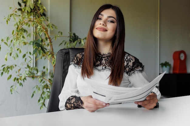 Successful confident business woman at her desk working with documents portrait