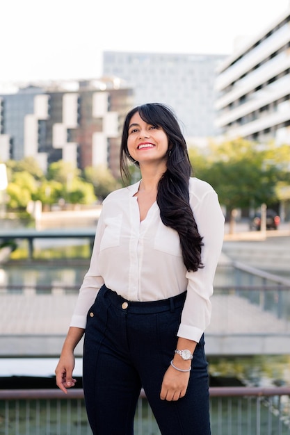 Successful curvy businesswoman smiling in the financial district of the city, concept of entrepreneur and urban lifestyle, copy space for text