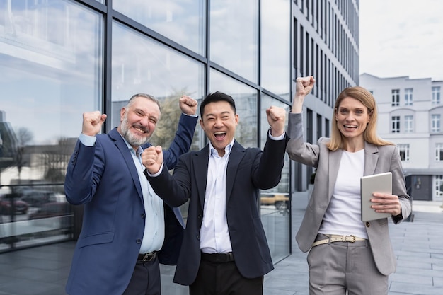 Successful diverse business team three loving men and woman looking at camera and happy celebrating