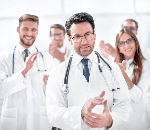 Successful doctor accepting congratulations from colleagues