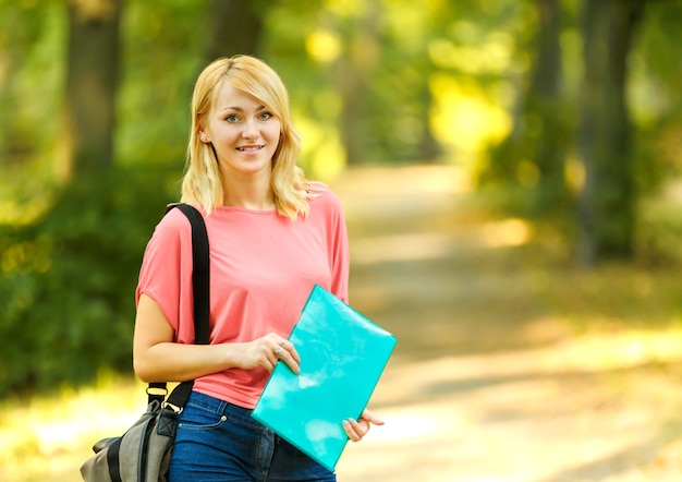 Successful girl student with books in the Park on a Sunny day