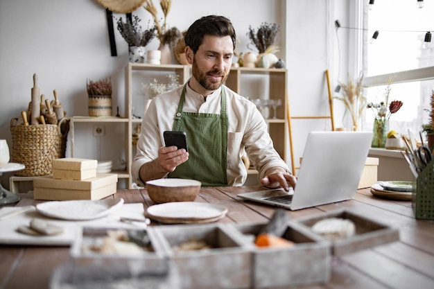 Photo successful guy store employee with ceramic tableware shoots photos