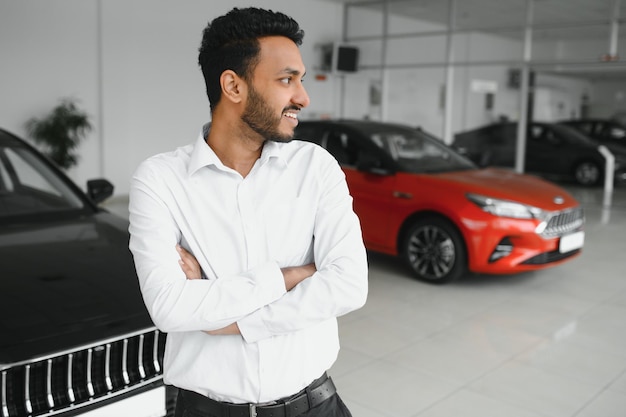 Successful indian businessman in a car dealership sale of vehicles to customers