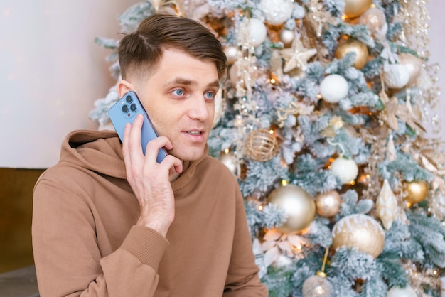 Successful man using smartphone against an Christmas tree Social media public