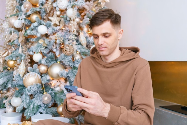 Successful man using smartphone against an Christmas tree Social media public