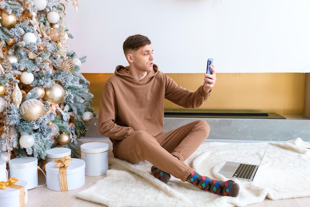 Successful man using smartphone against an Christmas tree Social media public