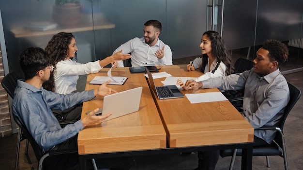 Successful multiethnic colleagues discussing idea project in office boardroom meeting Multiracial business team group of people discuss talking brainstorm managers workers partners working teamwork