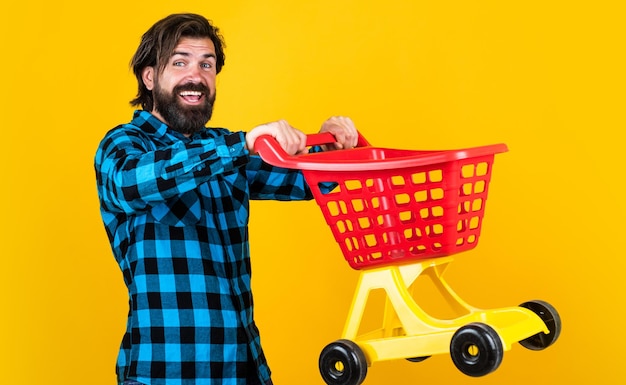 Successful shopping day happy bearded hipster carry shopping cart shopper concept brutal handsome man with moustache mature shopaholic in mall buy and purchase