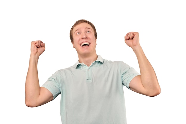 Successful smiling guy in mint Tshirt rejoices success white background triumph achievement